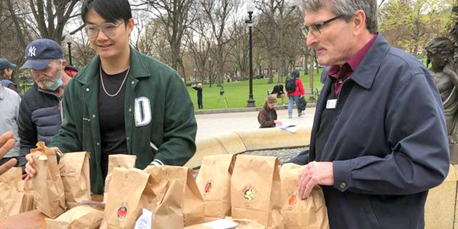 common catherdral Two people on Boston common distributing food from paper bags
